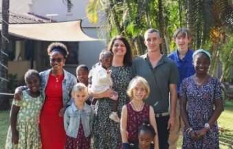 Families gathered outdoors in a Zambian village.